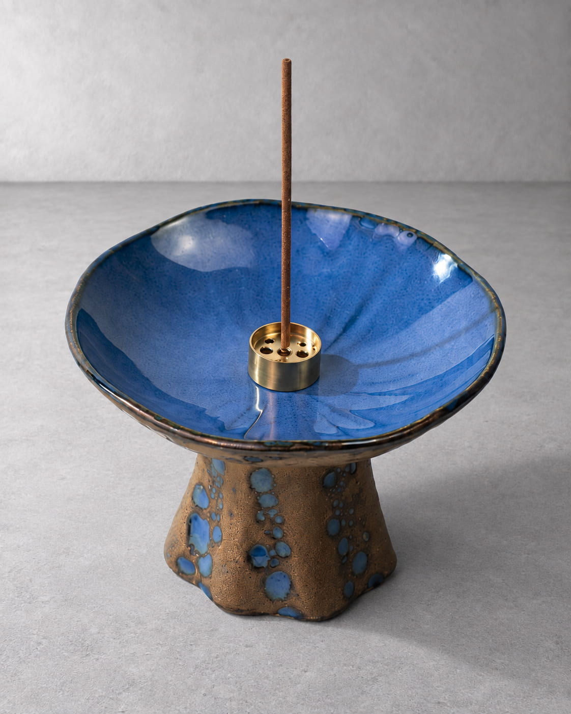 Close-up of the Azure ceramic incense holder showing blue reactive glaze, gold-tone insert, and kiln-fired pedestal details.