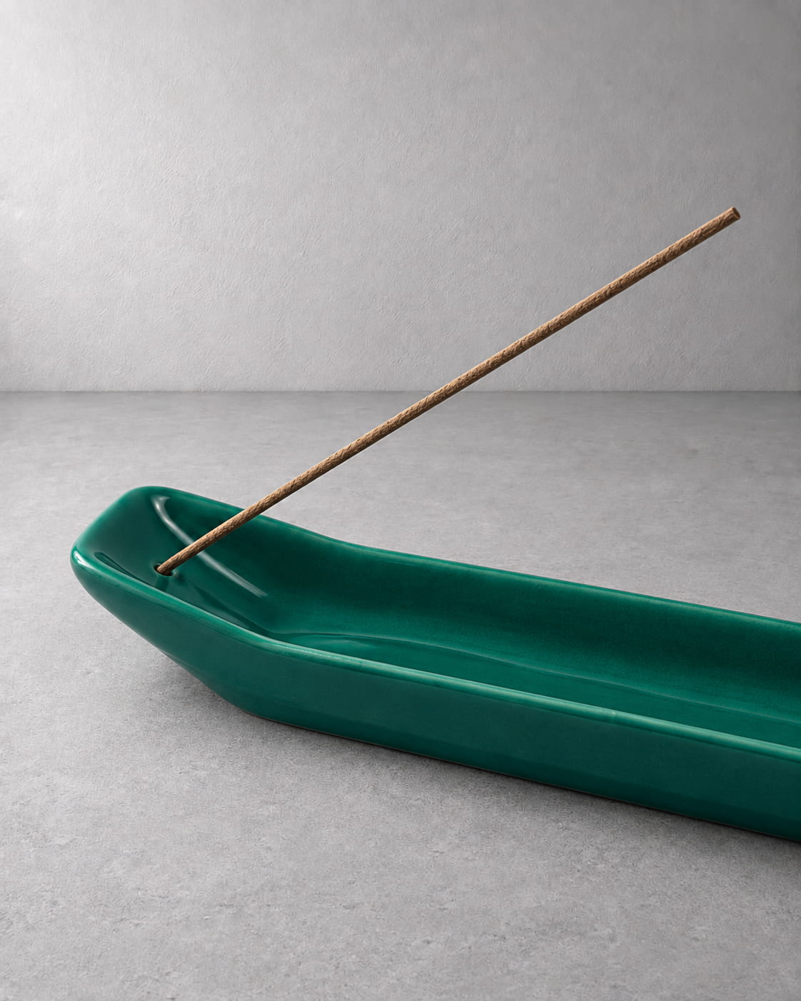 Close-up of the Emerald ceramic incense holder showing deep green glaze, incense opening, and curved tray details.